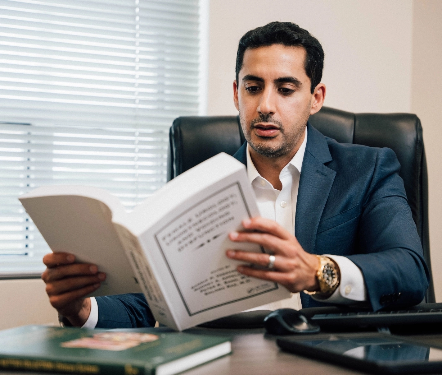 Dr. Dhir reading in his office. - Book Now in Webster, TX